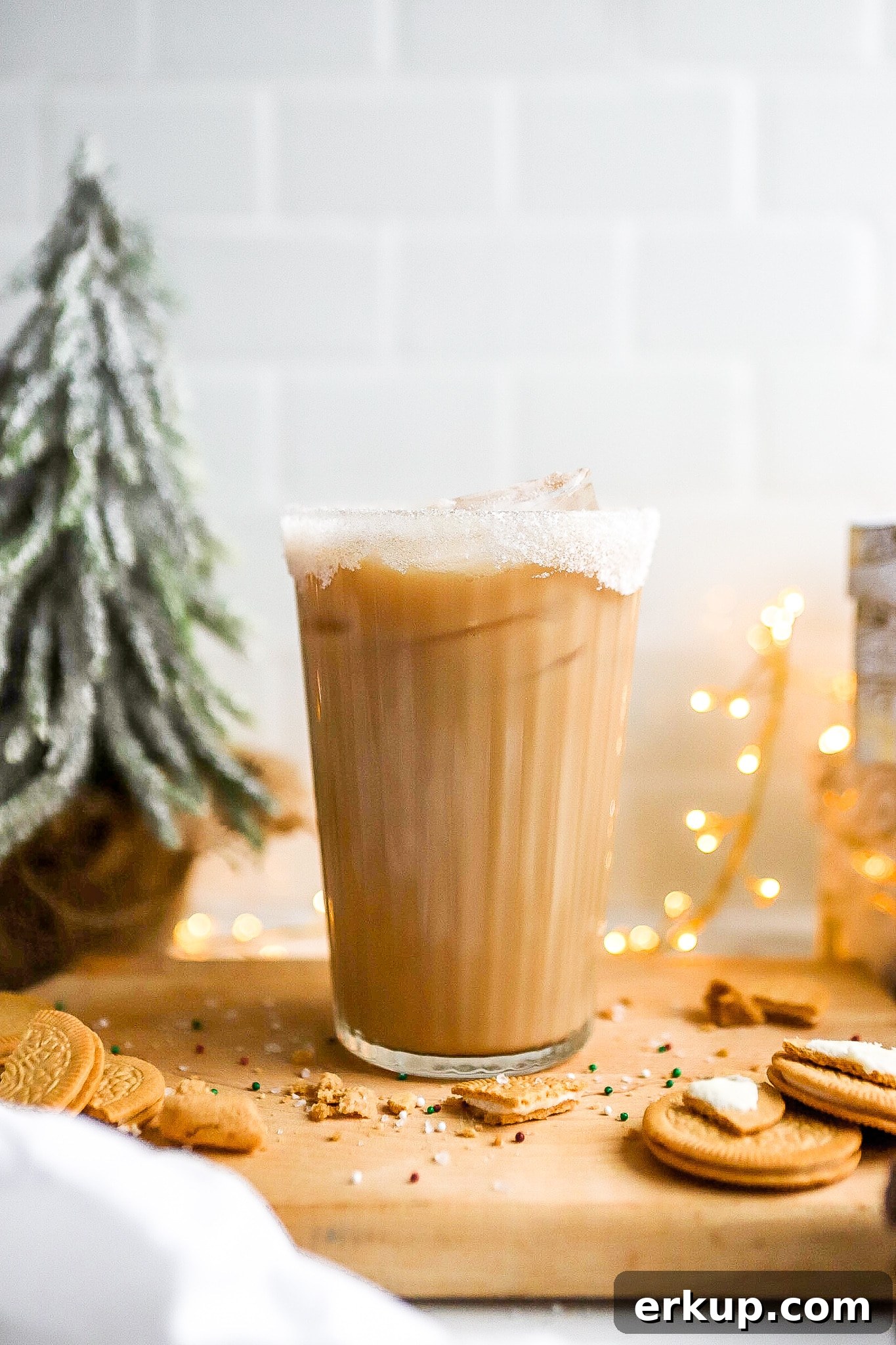 side angle of starbucks iced sugar cookie latte recipe in a glass with cookies scattered around