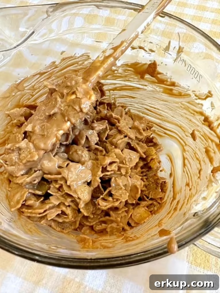 carefully folding the cornflakes into the peanut butter mixture