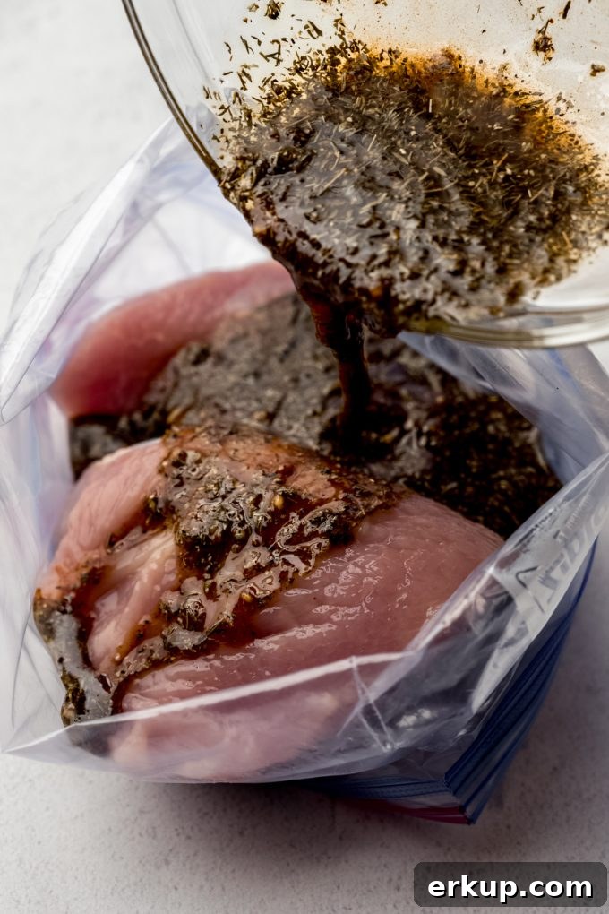 Juicy Oven-Roasted Turkey Tenderloin Recipe 7 Someone is pouring marinade into a zip top bag with turkey tenderloin in it.
