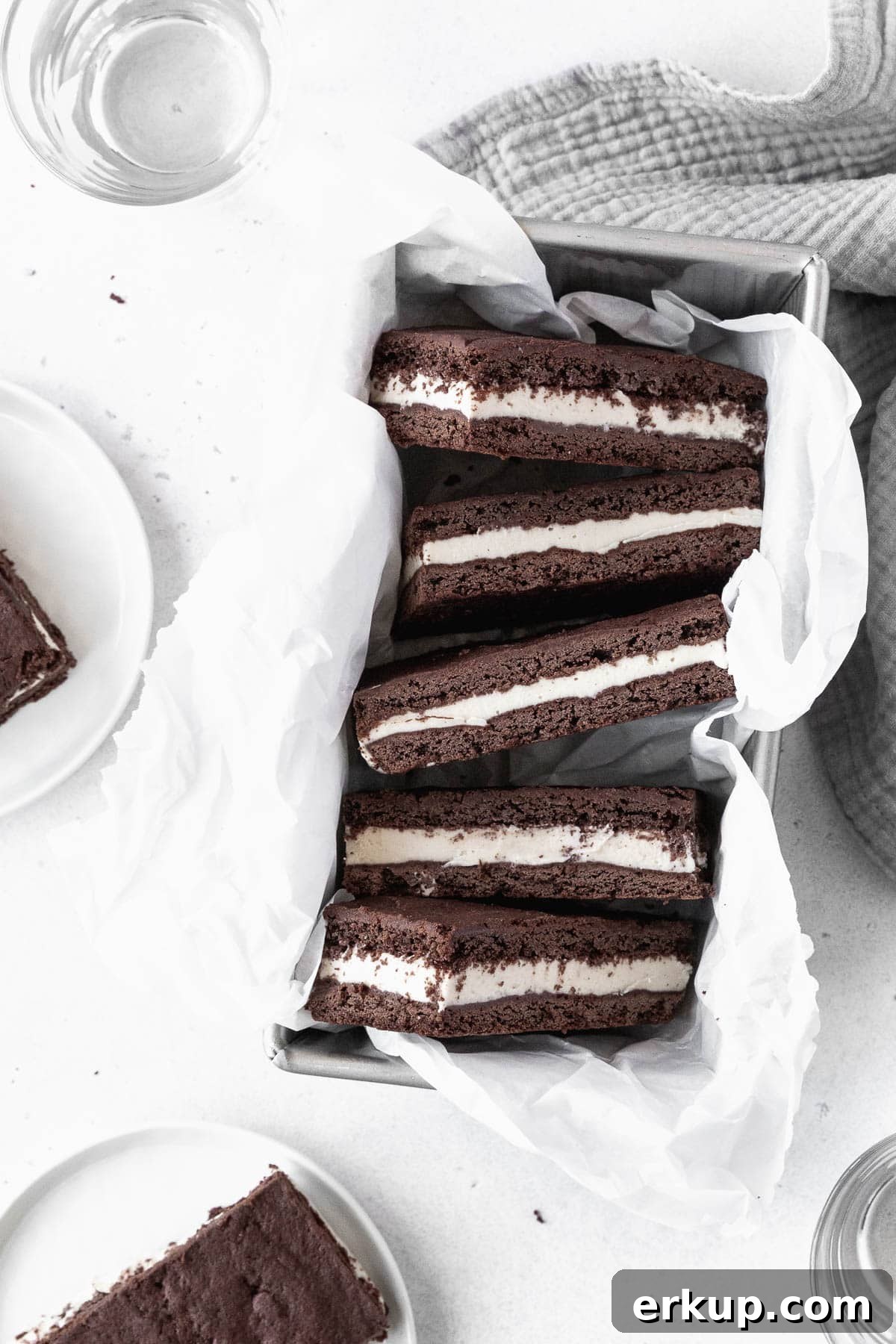 Ice cream sandwich cookies in a parchment paper-lined loaf pan.