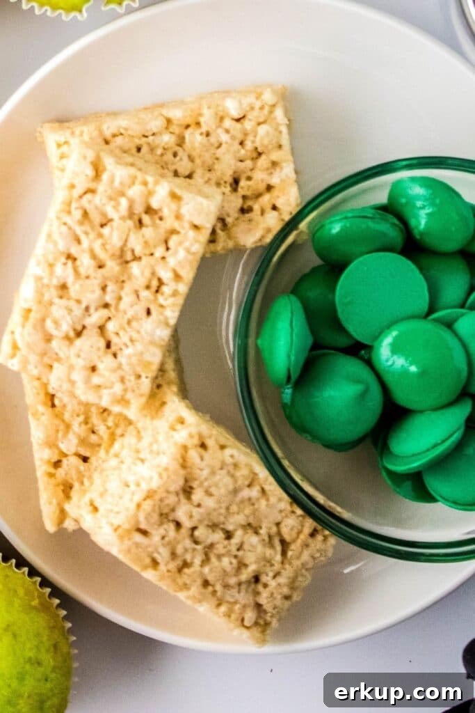 Spooky Frankenstein Rice Krispies Treats for Halloween 3 candy melts and rice krispies treats on white plate on counter