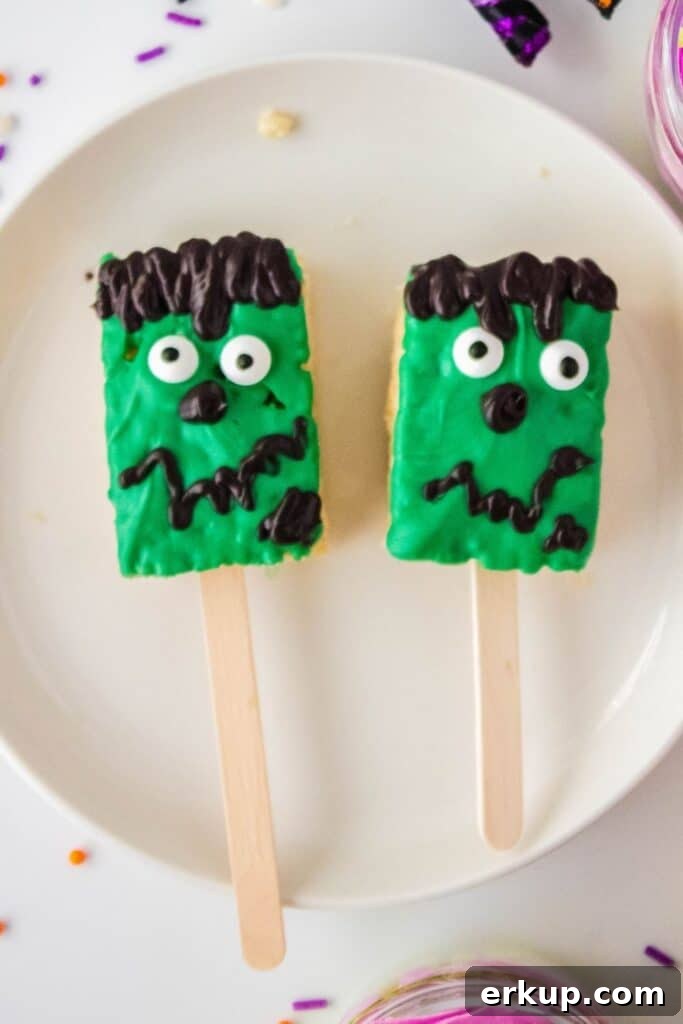 Spooky Frankenstein Rice Krispies Treats for Halloween 5 frankenstein treats on popsicle sticks on plate