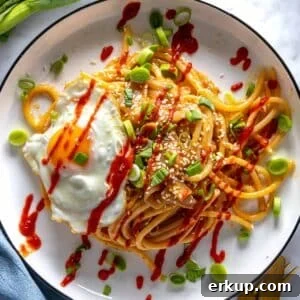 Miso pasta with a fried egg and sriracha sauce.