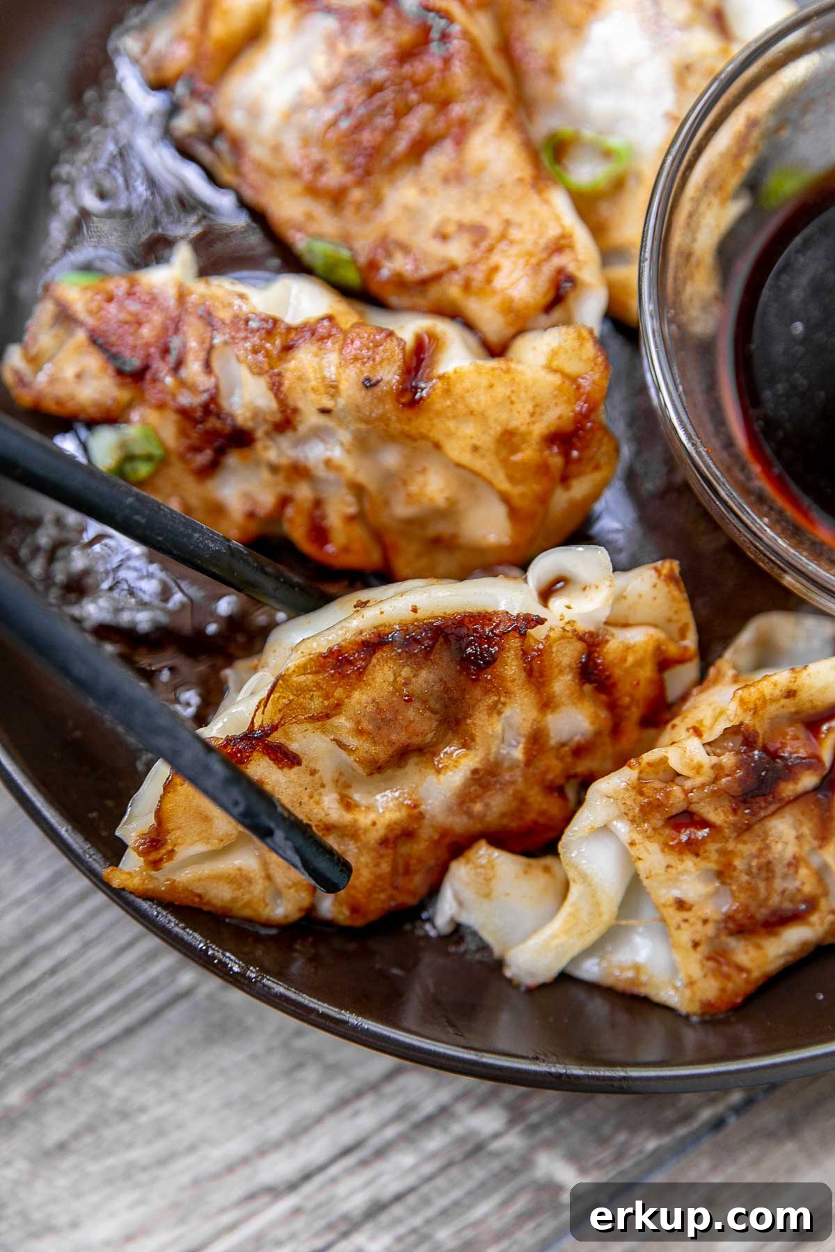 Pork potstickers with dipping sauce on a serving platter.
