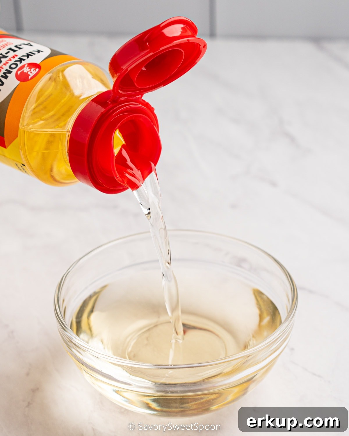 Substitute for Mirin: Options for Japanese Cooking 3 Bottle of mirin pouring into glass bowl.