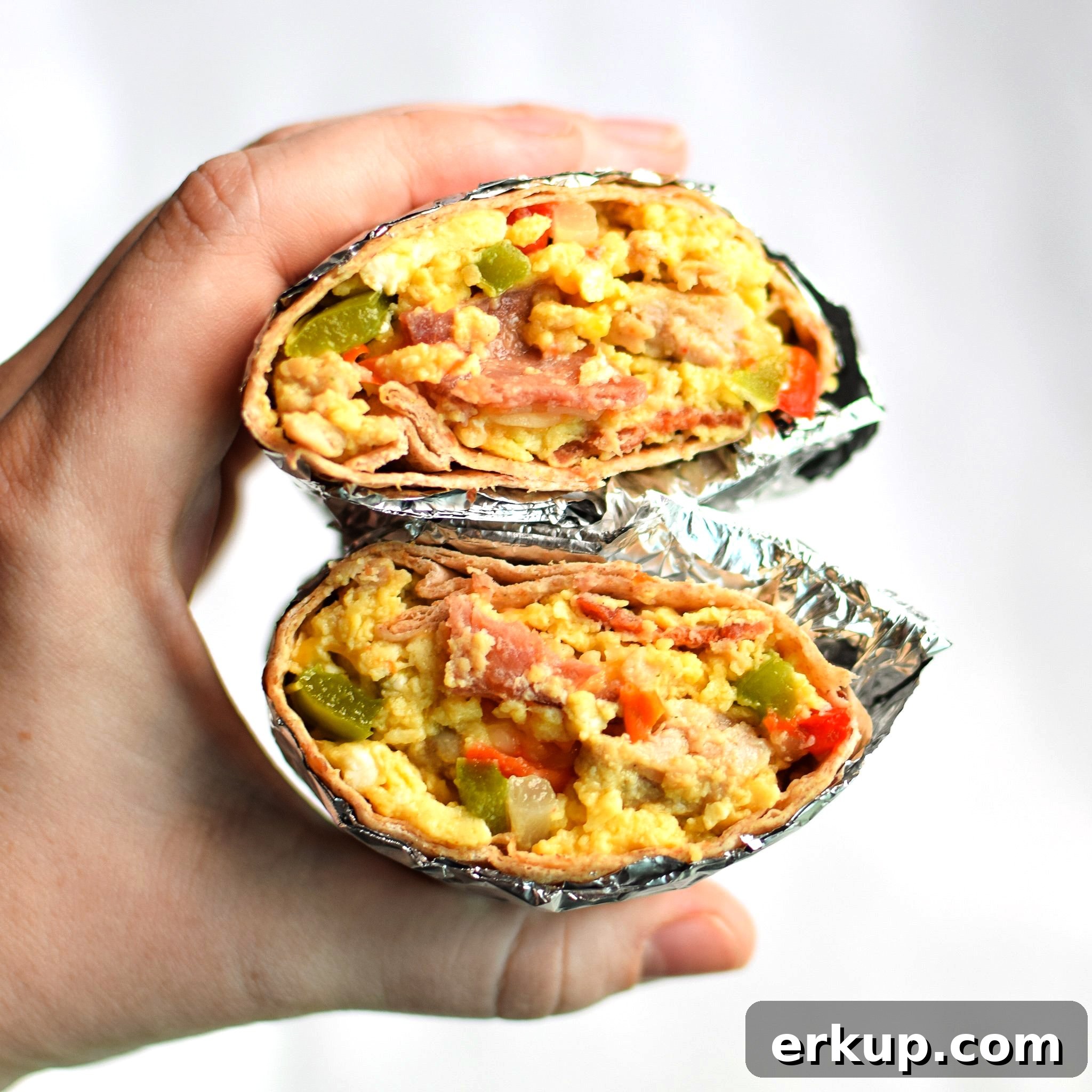 Holding a split in half breakfast burrito.