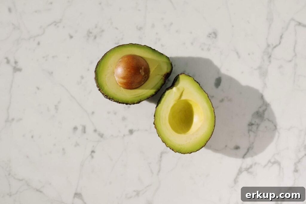 avocado sliced in half with the pit