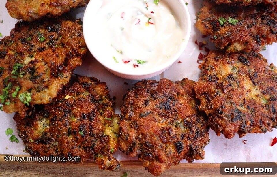 top view of chicken fritters placed on a plate next to each other. They are served with garlic -mayo dip.