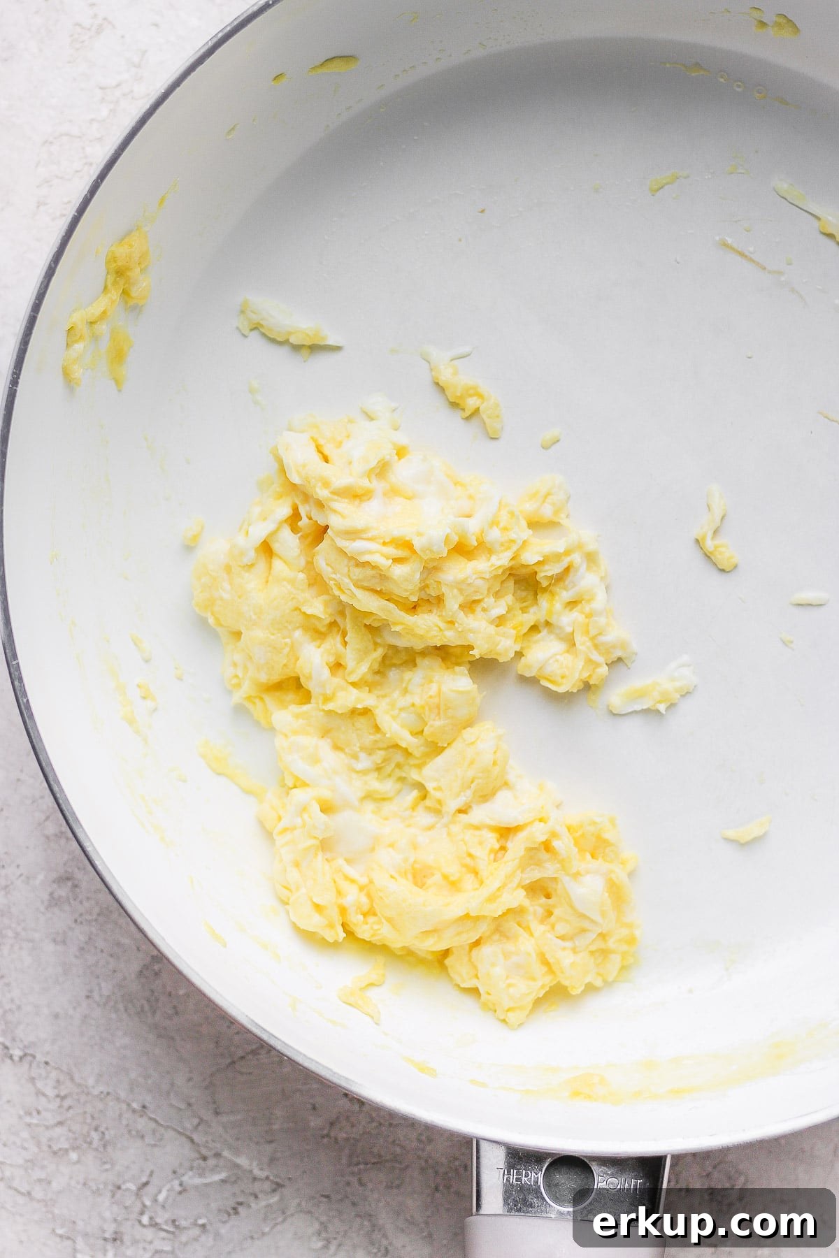 High-Protein Breakfast Tacos with Eggs and Avocado 4 Scrambled eggs in a white pan.