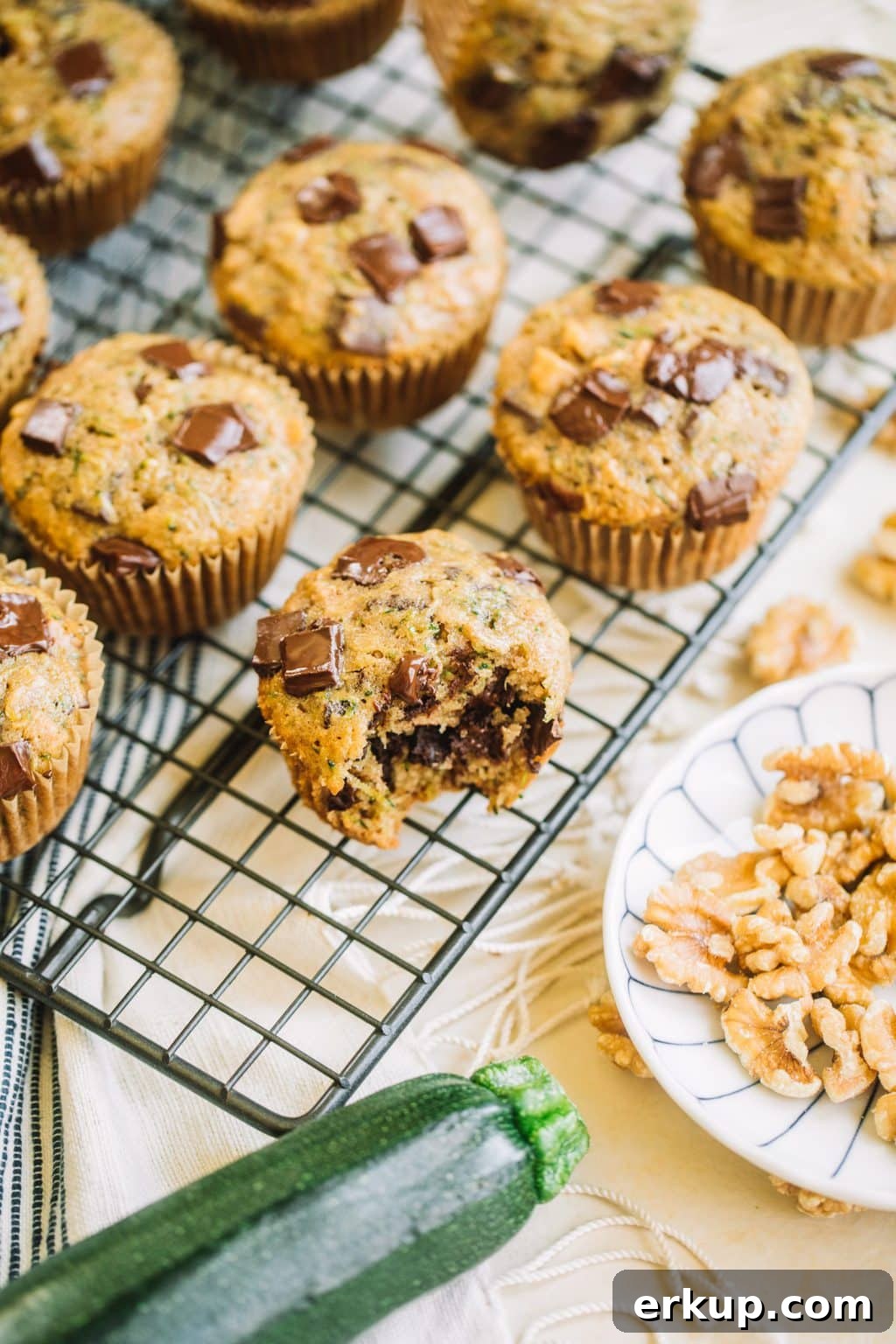 muffin recipe with zucchini and chocolate chips with bite taken out on wire rack