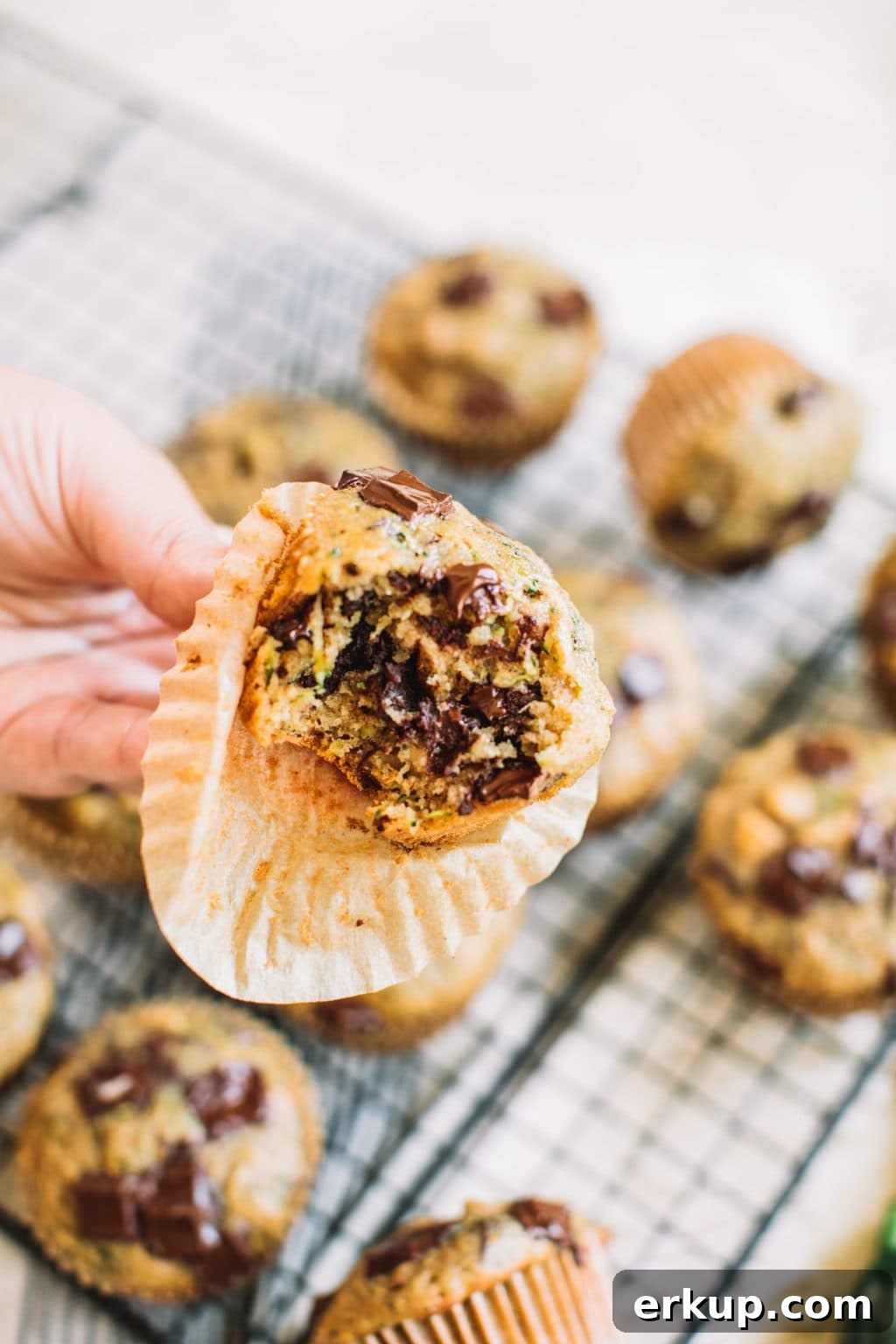 hand holding zucchini chocolate chip muffin with bite taken out