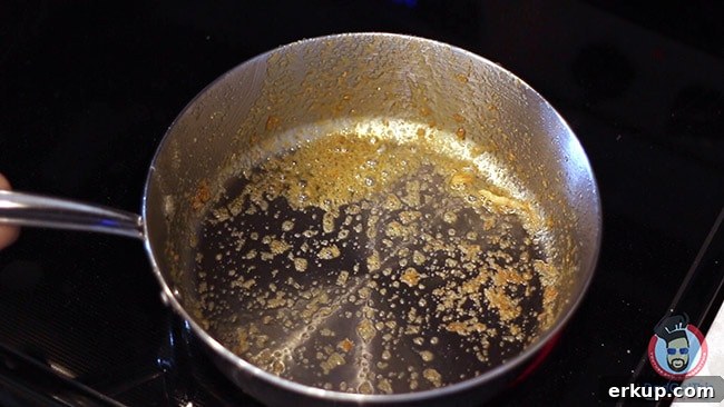 A Stainless steel pan on a burner making shrimp scampi