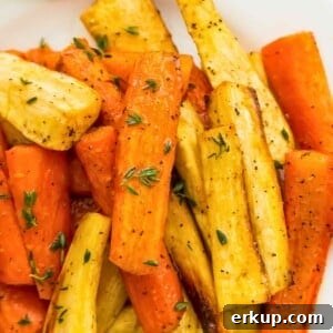 A plate full of honey glazed carrots and parsnips topped with fresh thyme.