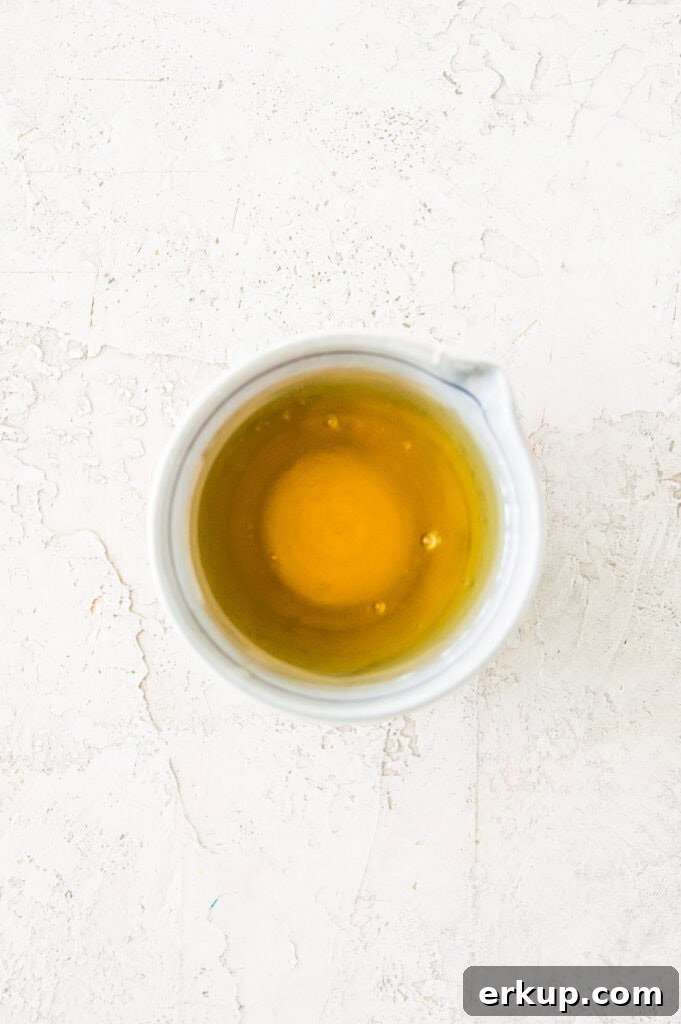 A small bowl filled with honey and melted butter.