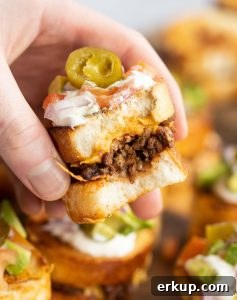 hand holding half eaten mini sandwich showing taco filling