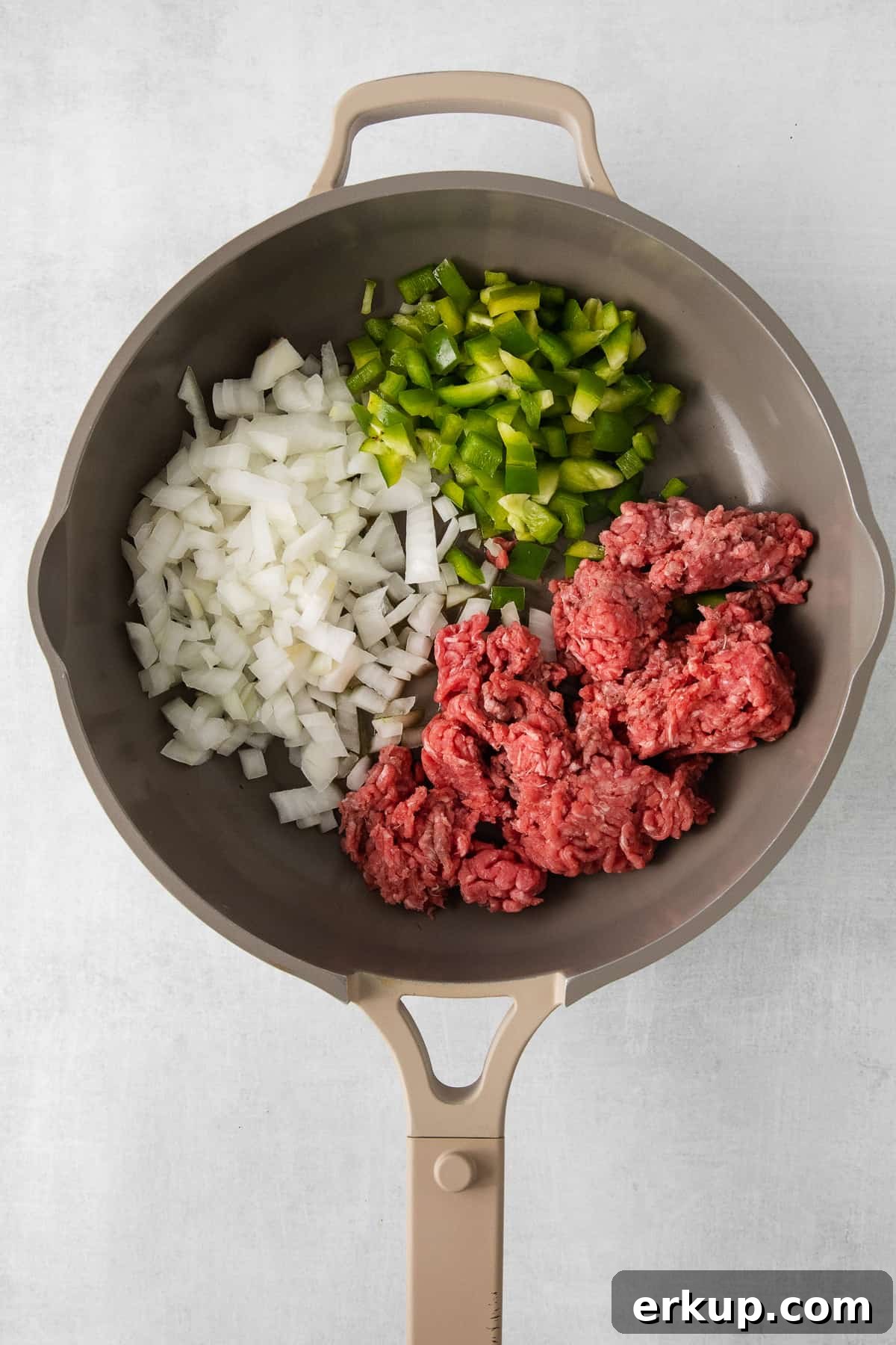 Ground beef and onion in a skillet.