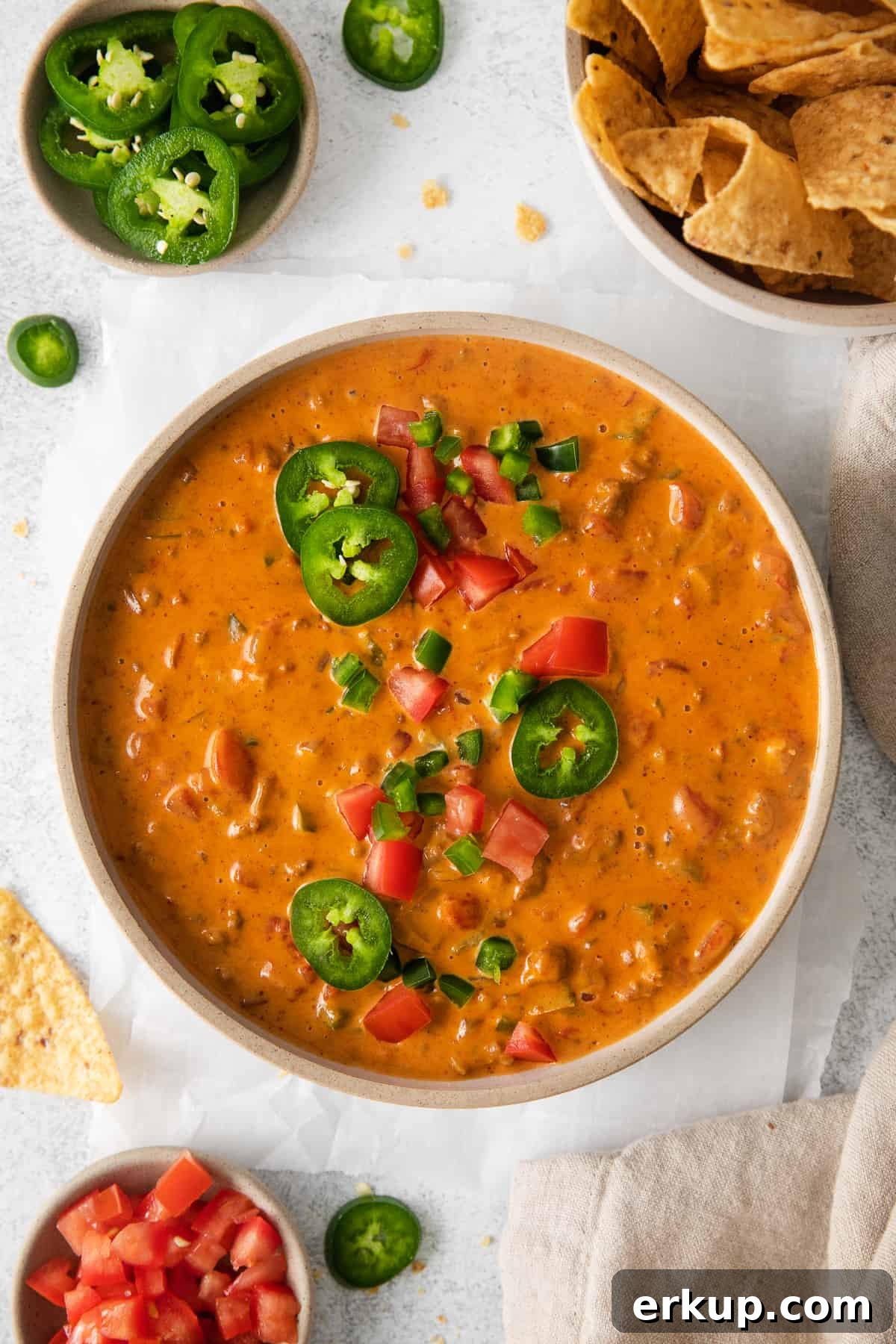 Velveeta chili cheese dip in a bowl topped with sliced jalapenos.