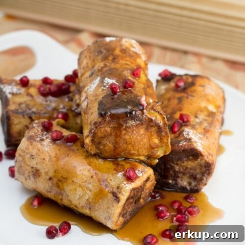 A platter of pain perdu topped with maple syrup and pomegranate arils.