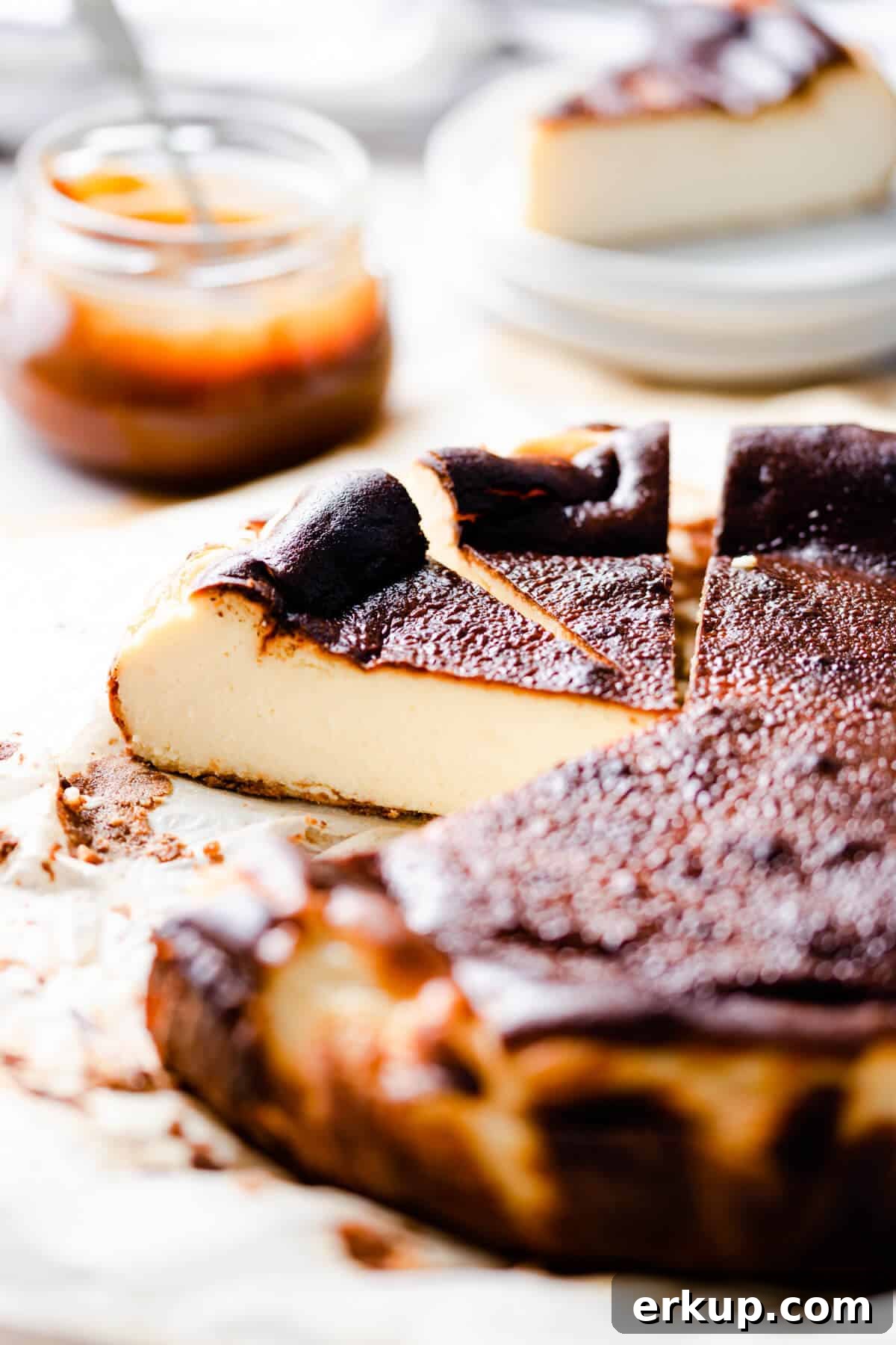 45 degree side shot of burnt basque cheesecake with couple of slices cut out