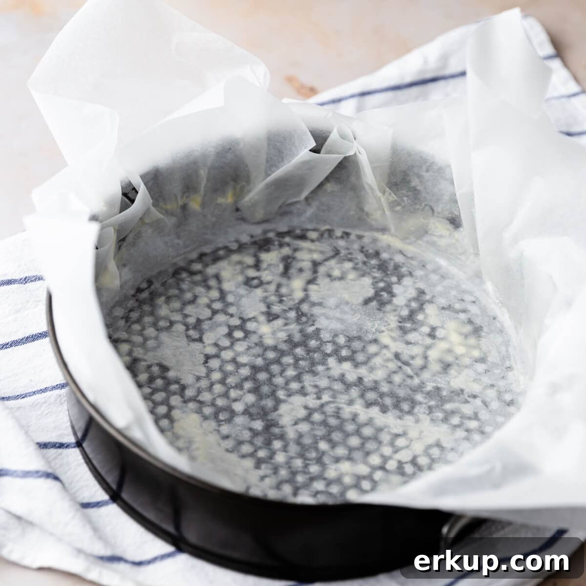 round baking tin lined with baking paper that overhangs