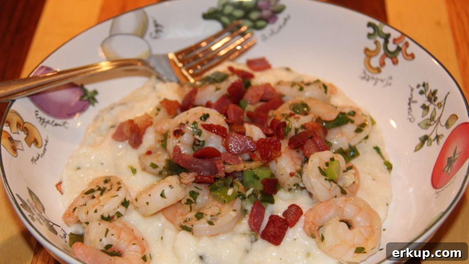 Bowl of creamy roasted poblano grits topped with shrimp and bacon