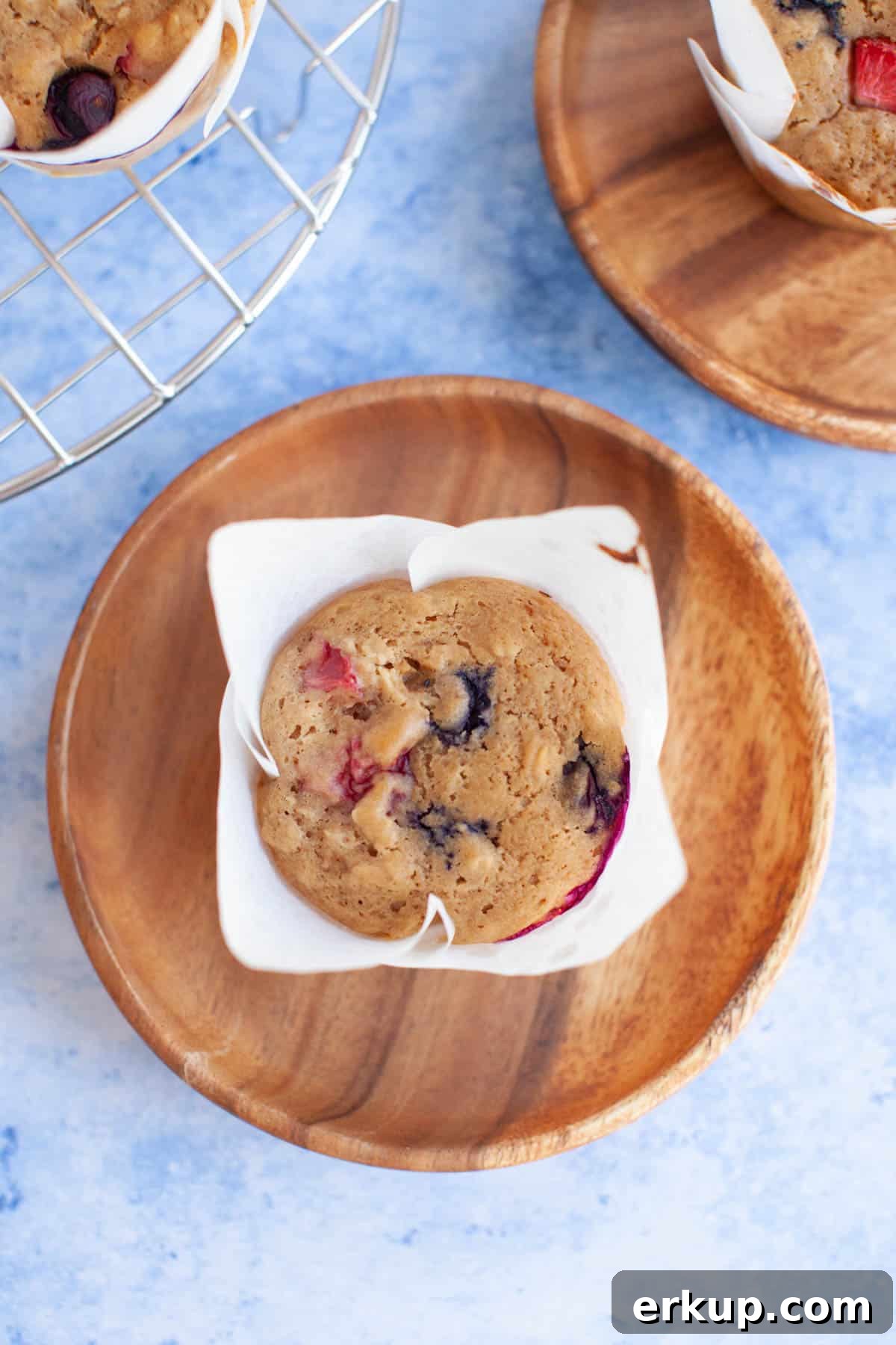 Mixed Berry Muffins Recipe: Moist Blueberry Raspberry Muffins 10 muffins on wooden plates on a blue counter.