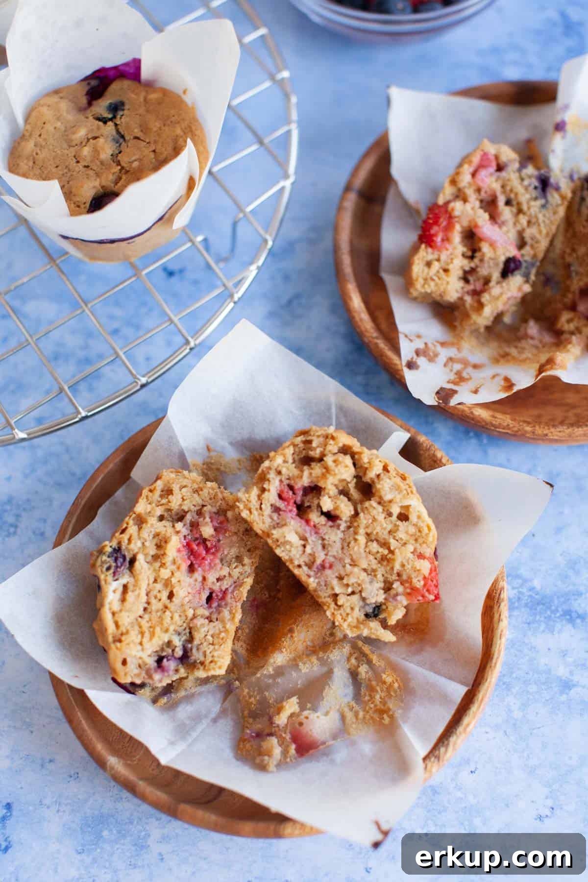 Mixed Berry Muffins Recipe: Moist Blueberry Raspberry Muffins 5 muffins that have been cut in half on wooden plates.
