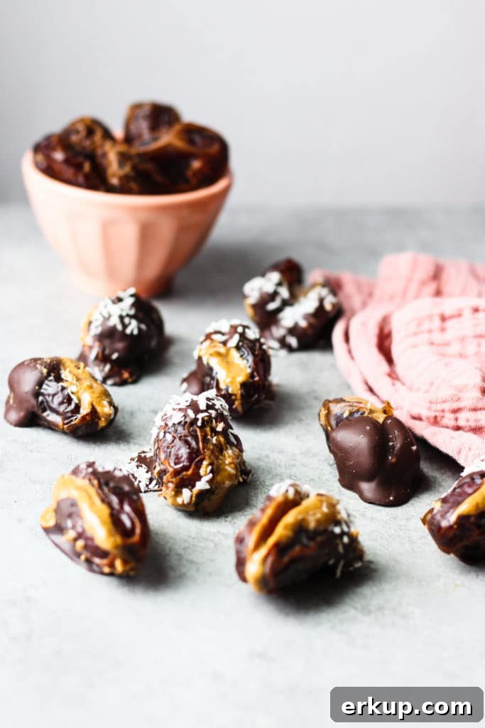 Almond Butter Stuffed Dates Recipe 2 Dates stuffed with almond butter and covered with chocolate and a bowl of plain dates in the background