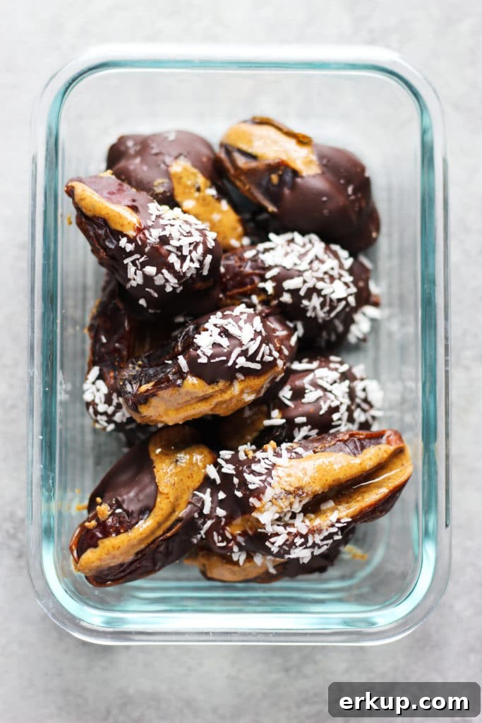 Almond Butter Stuffed Dates Recipe 5 A rectangular glass container with chocolate-covered dates sprinkled with coconut flakes