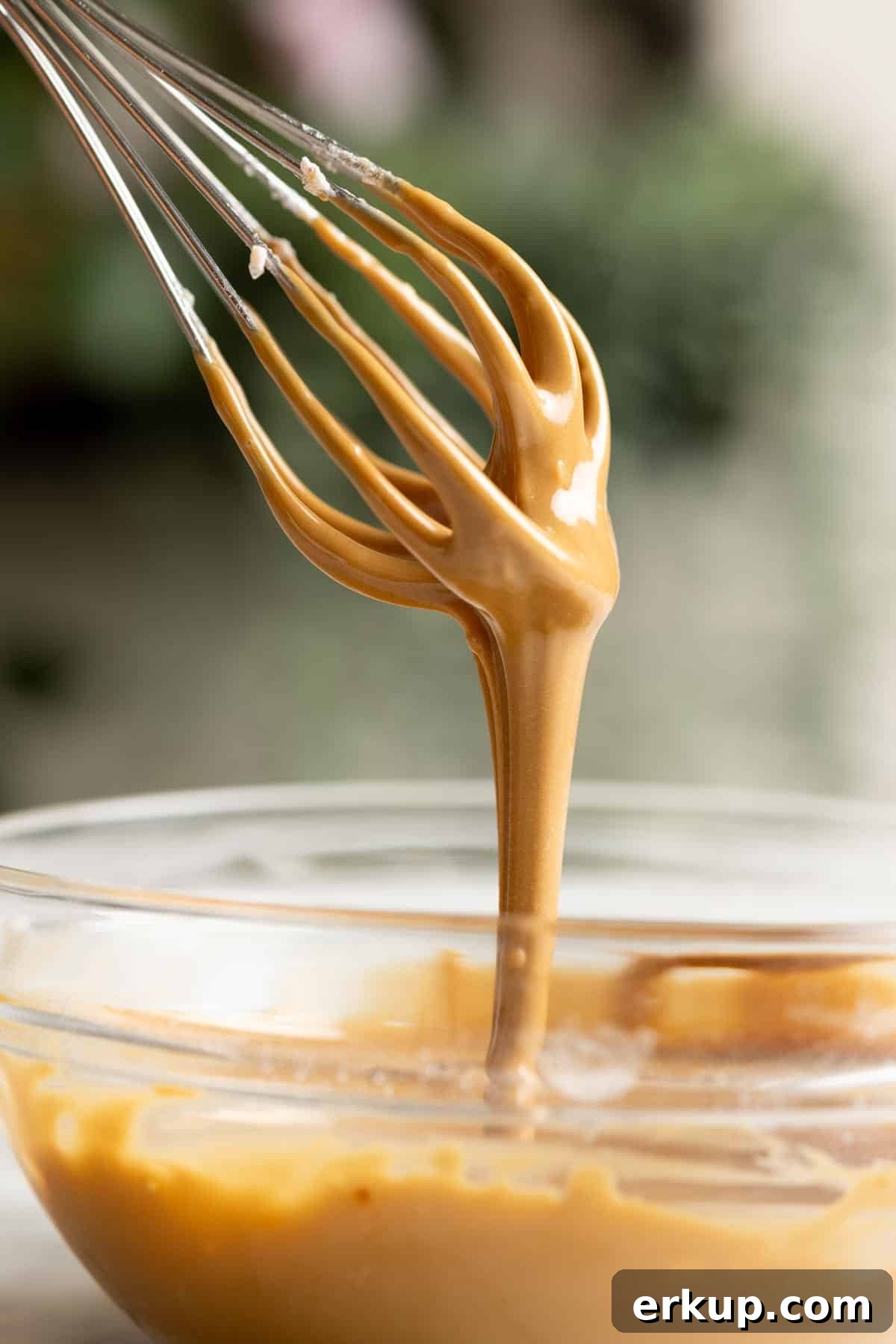 Vietnamese coffee glaze dripping down from a whisk.