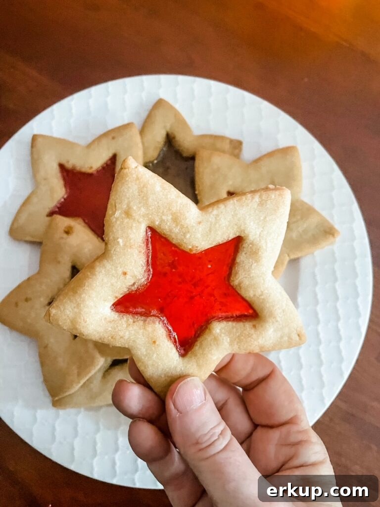 Stained Glass Cutout Sugar Cookies Recipe for Cookie Exchanges 3 A hand holding up one of the Stained Glass Cutout Sugar Cookies