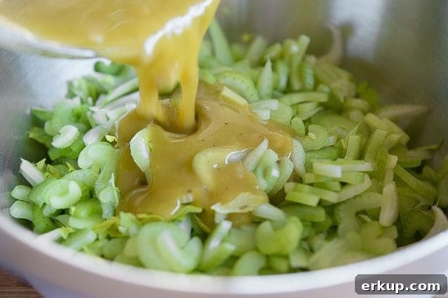 Pouring Lemon Vinaigrette Over Celery Slices in Bowl