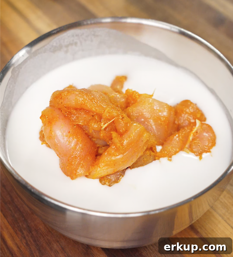 Hot Honey Butter Chicken Recipe 5 Seasoned chicken soaking in a bowl of buttermilk to tenderize before frying