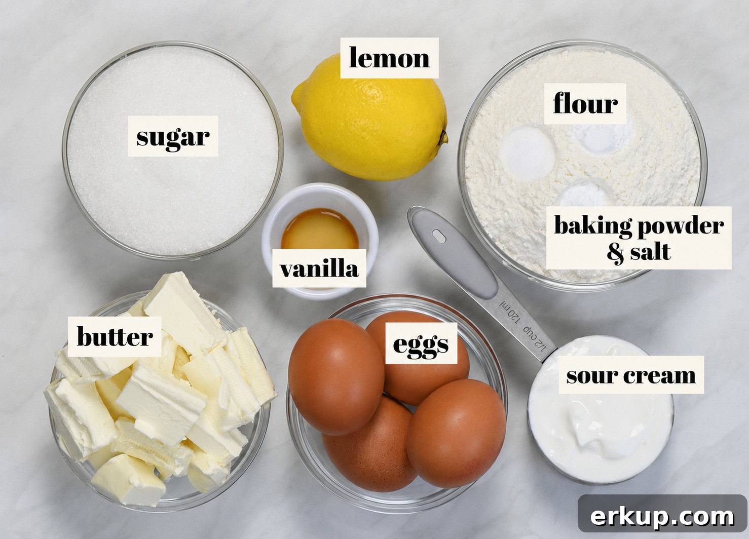 Ingredients for lemon pound cake including sugar, lemon, flour, baking powder, salt, vanilla, butter, eggs, and sour cream.