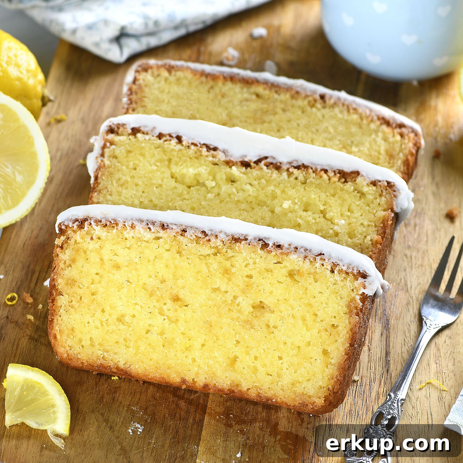 Close-up of moist lemon pound cake slices with thick lemon glaze and soft yellow crumb.