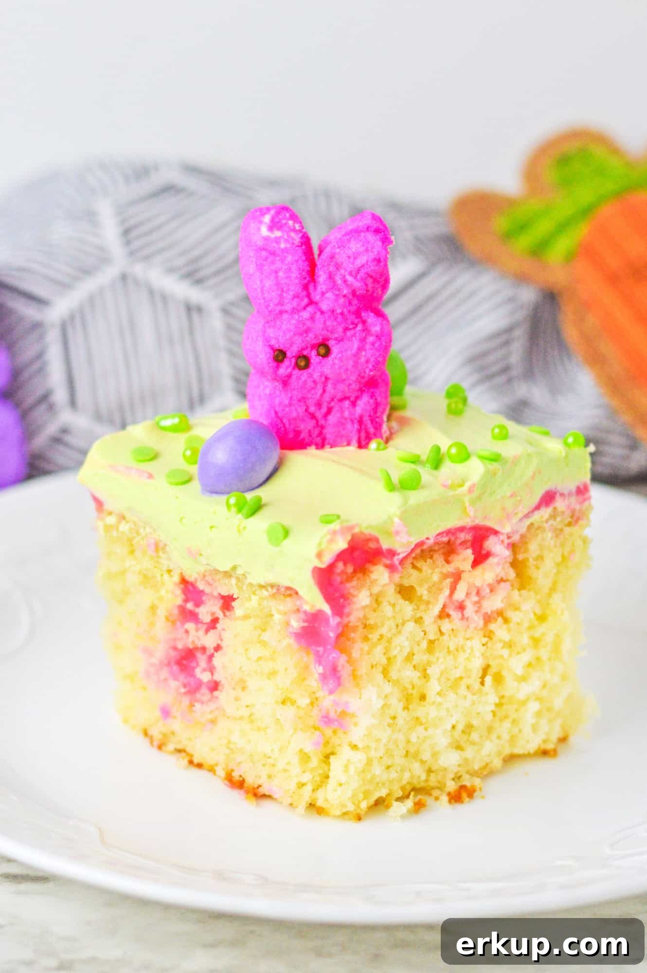 A slice of vanilla poke cake with easter peep and an easter egg