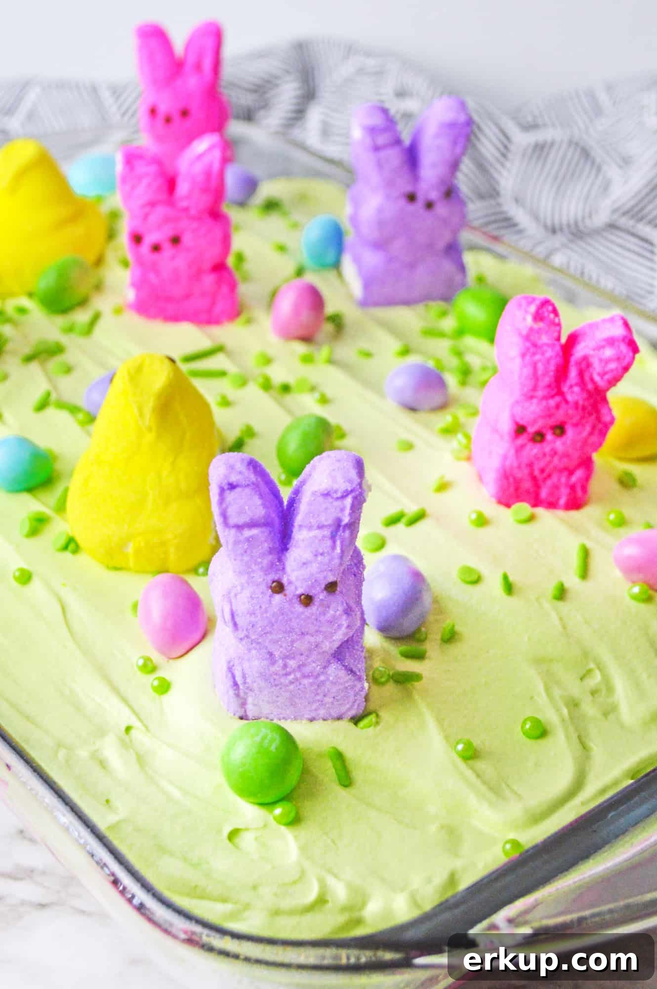 Easter poke cake with peeps, in a 9x13 inch glass pan.
