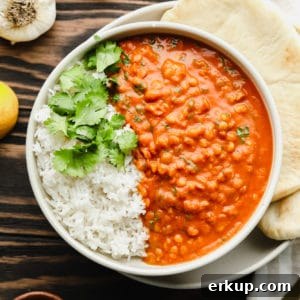 close up on lentil curry with white rice in a white bowl.