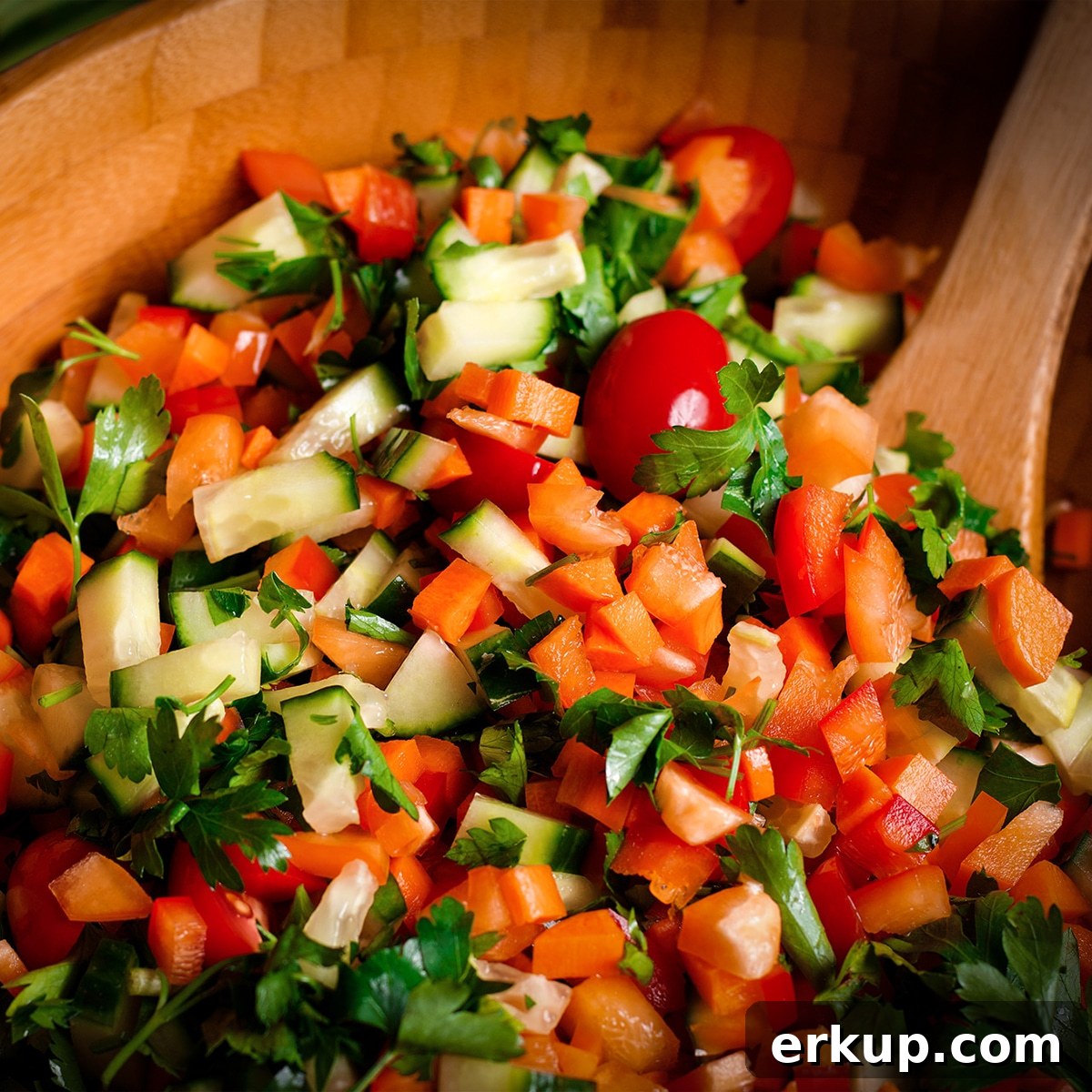 A wood bowl filled with Israeli Salad.