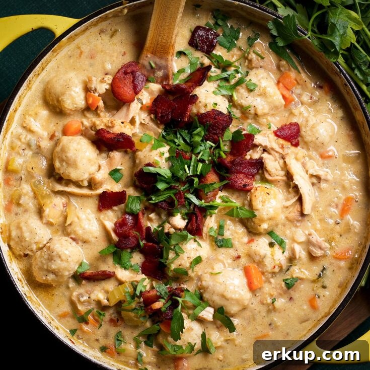 A pan filled with chicken and wild rice soup topped with crispy bacon and chopped parsley, ready to serve.