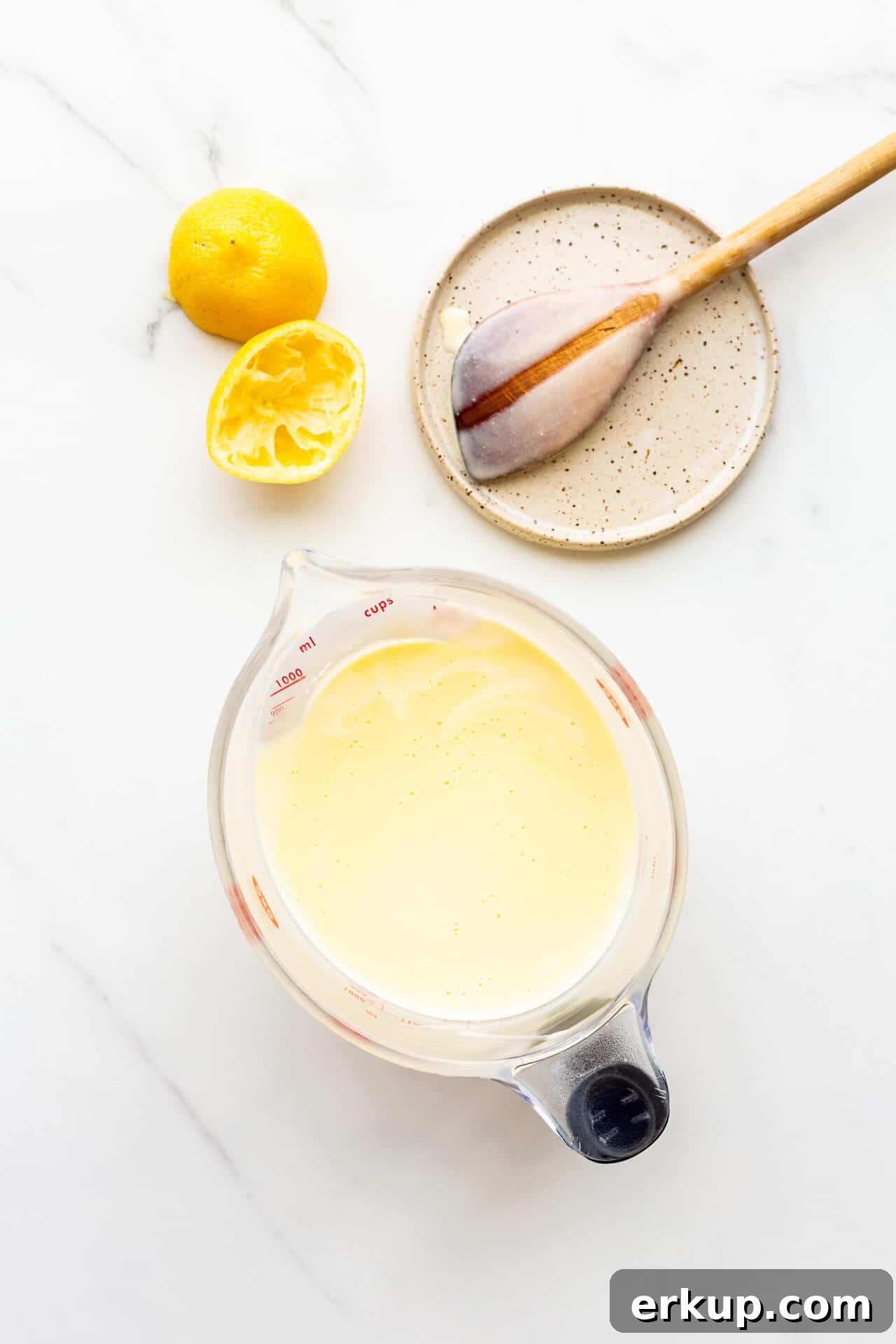 Custard base for lemon ice cream with spoon on plate to show the custard coats the back of the spoon