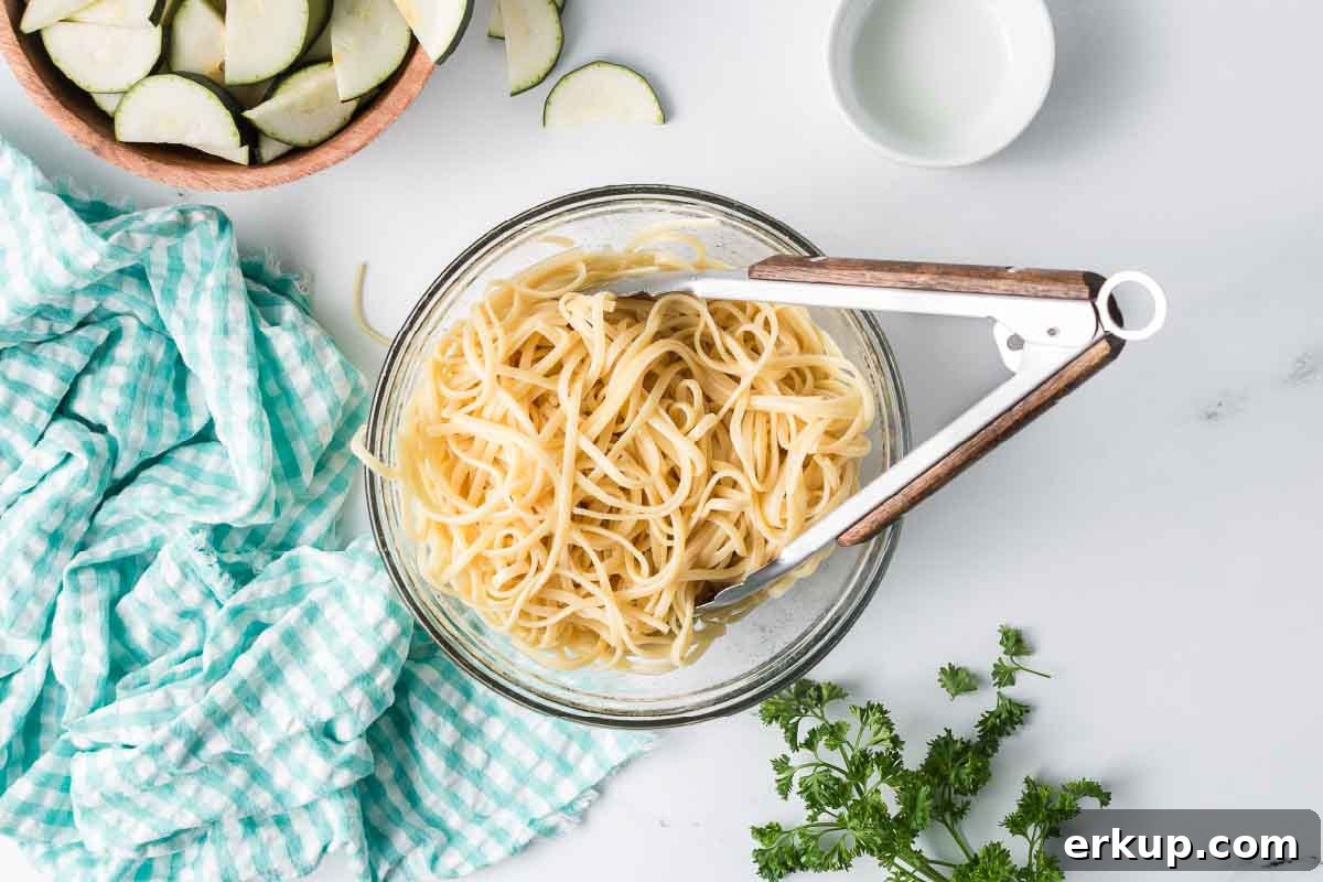 Lemon Garlic Zucchini Linguine with Parmesan 4 Cooked linguine in a bowl with a bowl of sliced zucchini nearby.