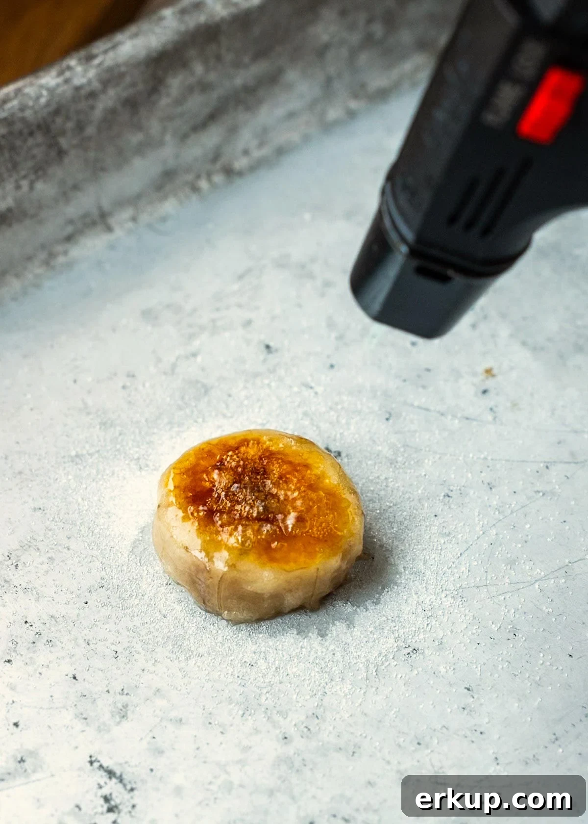 banana being torched to make a brûléed banana garnish