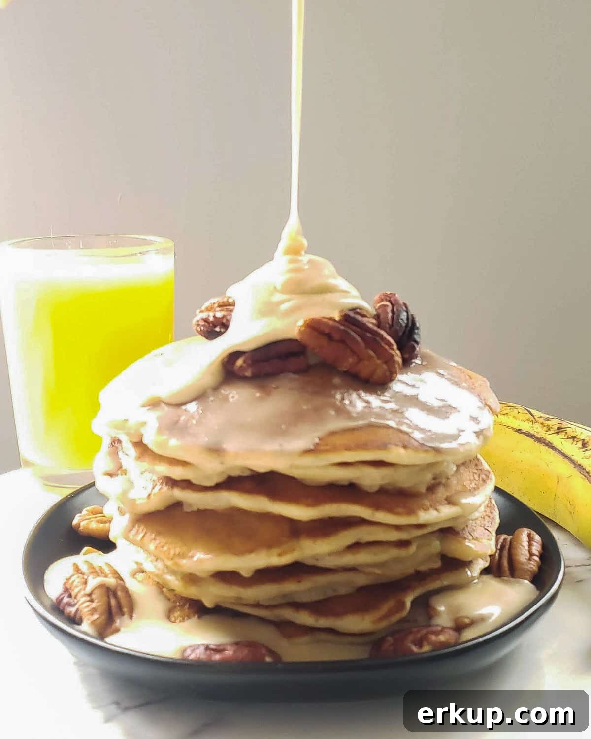 brown butter maple glaze drizzling onto banana pancakes