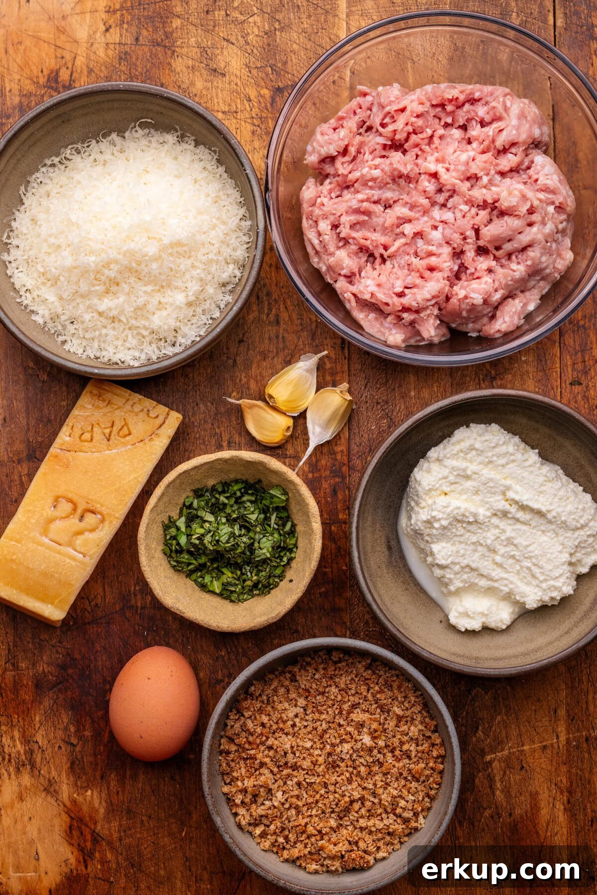 Classic Italian Chicken Meatballs in Marinara Sauce 3 Ingredients for Italian chicken meatballs arranged in different sized bowls on a wooden background.