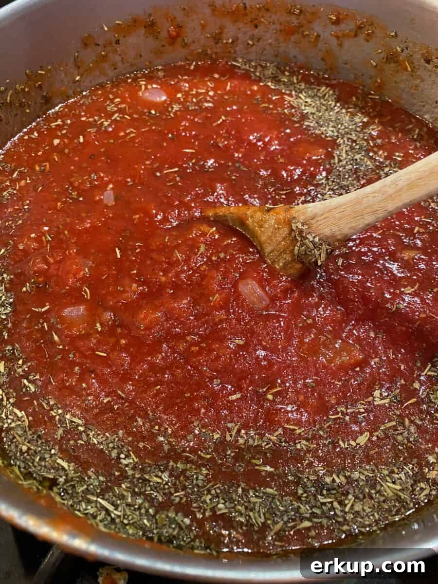 Creamy Cheesy Baked Ziti Casserole Recipe 5 Red sauce with Italian seasoning in a large stock pot on the stove.