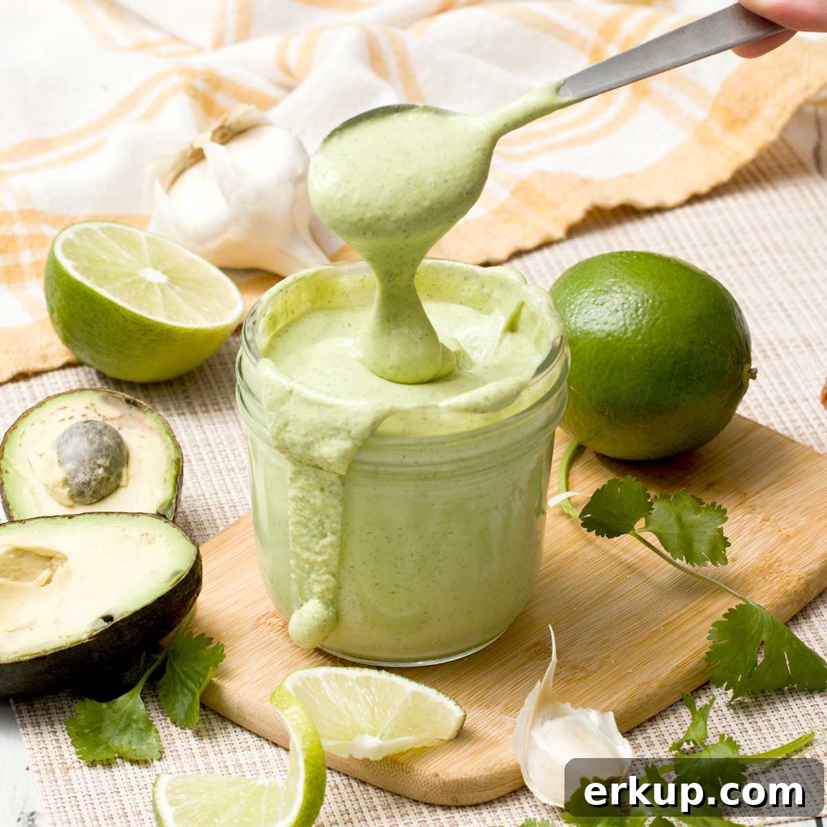 Copycat Chick-fil-A Avocado Lime Ranch Dressing Recipe 2 A spoon lifting avocado lime ranch dressing out of a mason jar.