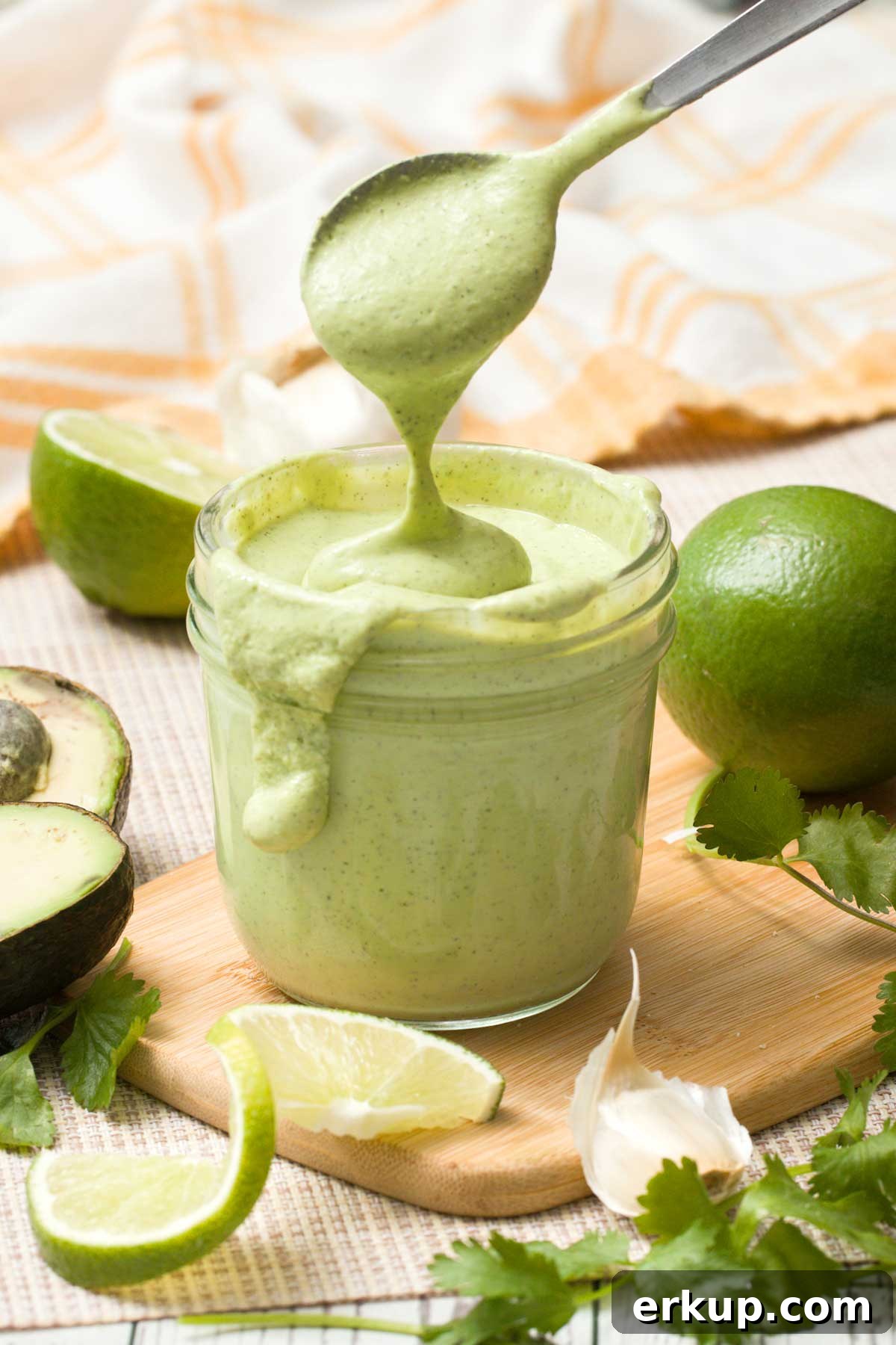 Copycat Chick-fil-A Avocado Lime Ranch Dressing Recipe 4 A mason jar with Chick-fil-A copycat dressing dripping off a spoon.