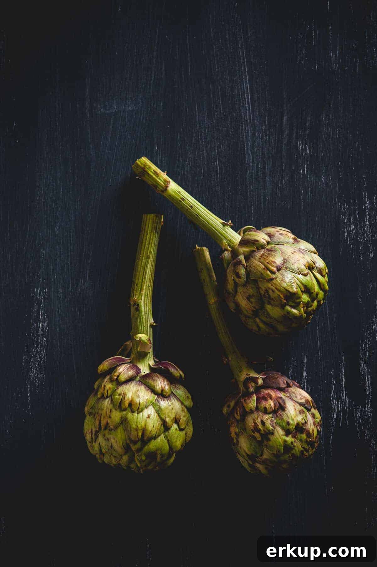 three artichokes on a table