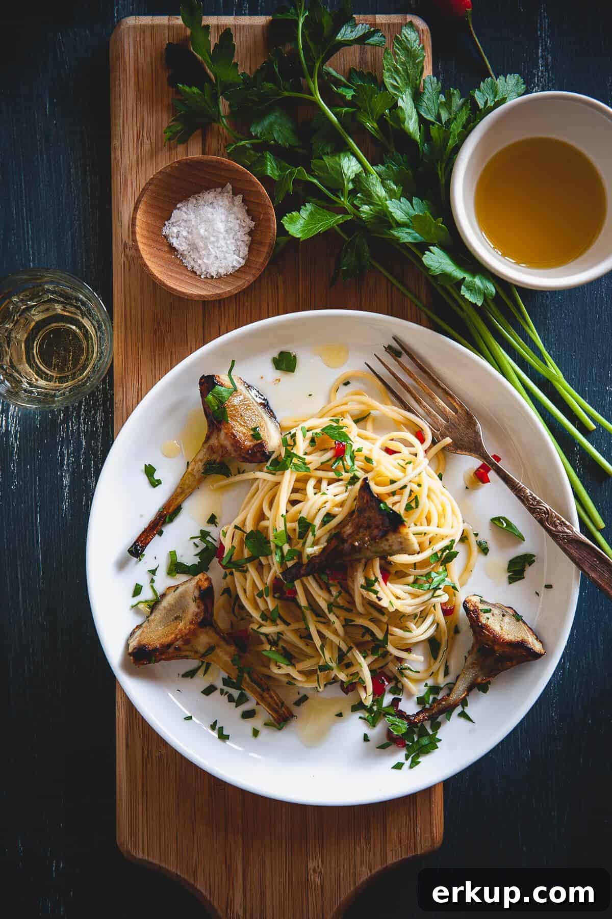 spaghetti with artichokes served in a plate on a board
